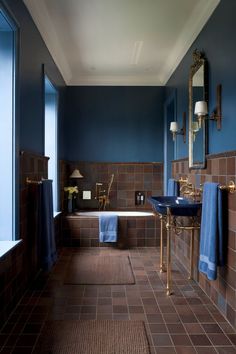 A luxurious brown bathroom design with deep blue walls and gold fixtures, providing a rich and elegant feel. Gold Bathroom Inspiration, Brown And Gold Bathroom, Blue Brown Bathroom, Gold Bathroom