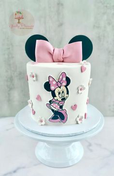 a minnie mouse cake with pink bow on top