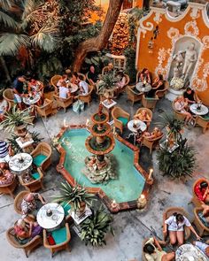 an overhead view of people sitting at outdoor tables and chairs in the middle of a courtyard