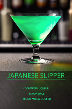 a green liquid in a martini glass on a bar