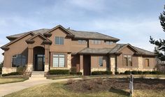 a large brown house sitting on top of a lush green field