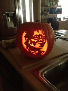 a carved pumpkin sitting on top of a kitchen counter