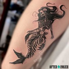 a woman's arm with a skeleton and fish tattoo on the left side of her body