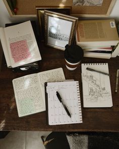 a desk with books, pens and pictures on it