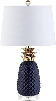 a blue table lamp with a gold pineapple on it and a white lampshade