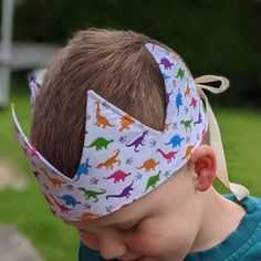 a young boy wearing a headband with dinosaurs on it