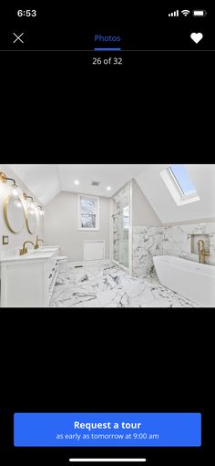 a bathroom with white marble floors and walls, along with a skylight above the bathtub