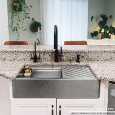 a kitchen sink with two faucets and a counter top in front of it