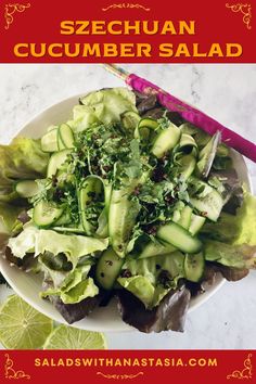 a white plate topped with cucumber salad next to sliced limes and cilantro