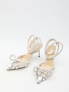 These high heels feature a transparent upper adorned with large stones and silver-tone crystals. The pointed toe is accented with a double crystal bow, while an adjustable ankle strap adds practicality. The leather insole and stiletto heel provide comfort and elegance, while the leather sole ensures durability. A dust bag and additional crystals and heels are also included. Heel height: 3.3 inches Size nationality: IT Product code: FW24-S081885X03B20 Composition: 100% pvc Chic High Heels, Bow High Heels, Fendi Wallet On Chain, Silver High Heels, Tom Ford Handbags, Margiela Shoes, Double Bow, Silver Heels, Designer Sandals