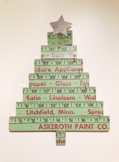 a christmas tree made out of rulers with a star on top, and the words above it