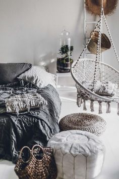 a bedroom with white walls and lots of pillows on the floor next to a hammock