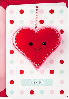 a valentine's day card with a red heart hanging from a string and the words love you on it