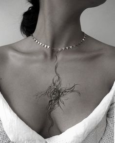 a woman wearing a white dress with a tattoo on her chest