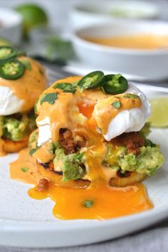 two appetizers are sitting on a plate with sauce and green garnish