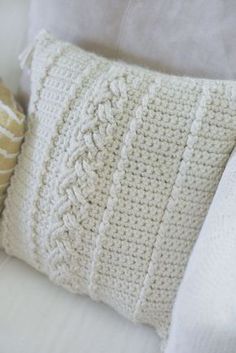 a crocheted pillow sitting on top of a white couch