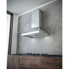 a stove top oven mounted to the side of a wall above a wooden countertop