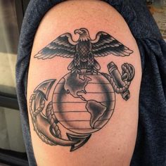 a man with a tattoo on his arm has an eagle, globe and anchor around it