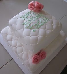 a cake with white frosting and pink roses on top