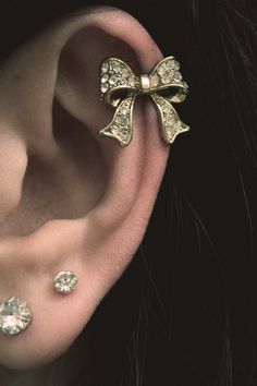 a close up of a person's ear with two bows on it