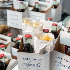 bottles of wine and snacks are on display at a wedding or other function in boxes