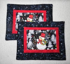 two quilted placemats with snowmen and christmas trees on them, one in red and the other in black