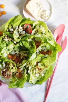 lettuce with tomatoes, feta cheese and other toppings on a plate