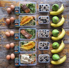 several plastic containers filled with food on top of a wooden table next to eggs and bananas