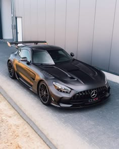 the mercedes amg gtr is parked in front of a building with its hood up