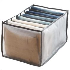 an open storage bag filled with clothes on top of a white surface and black trim around the bottom