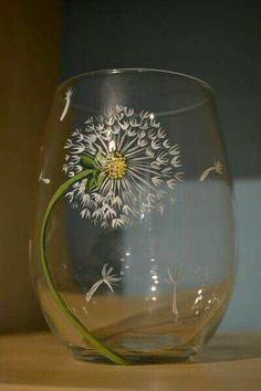 a glass with a dandelion painted on it