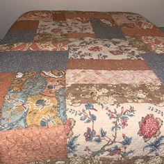 the bed is made up with many different colors and patterns on it, including flowers