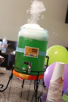 a large green machine sitting on top of a counter next to balloons and other items