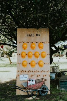 an old game board with oranges on it sitting in the grass under a tree