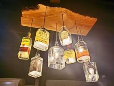 six hanging glass jars with labels on them