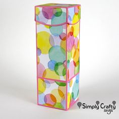 a colorful box with circles painted on the inside and sides, sitting upright against a white background