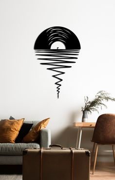 a living room with a couch, chair and wall sticker that has an abstract design on it