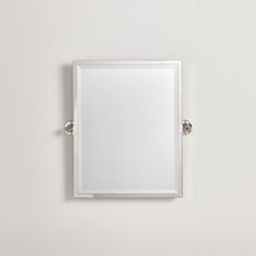 a white square mirror mounted on the wall