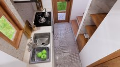 an aerial view of a kitchen sink and counter with green apples in the drainer