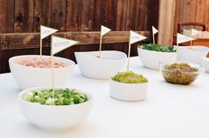 bowls filled with food sitting on top of a table next to small flags that say welcome