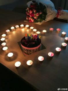 a birthday cake surrounded by lit candles on a table