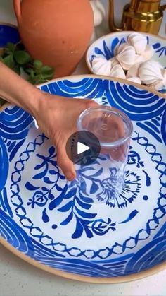 a person's hand on a blue and white plate