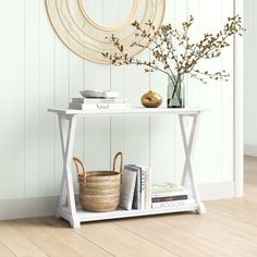 a white table with some books and vases on it