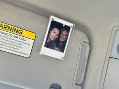 a warning sign on the back seat of a car next to a photo of two women