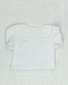 a white knitted cardigan and diaper cover