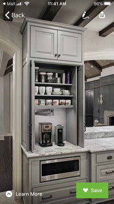 a kitchen with gray cabinets and white counter tops, an oven and coffee maker in the corner