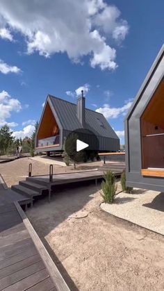 two small houses sitting next to each other on top of a dirt field with stairs leading up to them