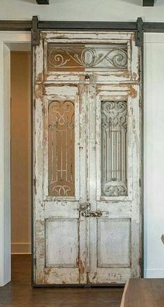 an old wooden door in the middle of a room with white walls and wood flooring