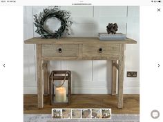 a wooden table with two drawers and a candle next to it on top of a rug