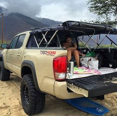 a woman sitting in the back of a pick up truck